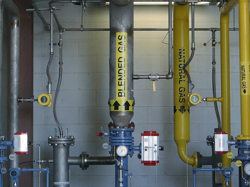 vertical pipes inside factory; yellow fci flow meters inserted in pipes labeled "blended gas" and "natural gas"