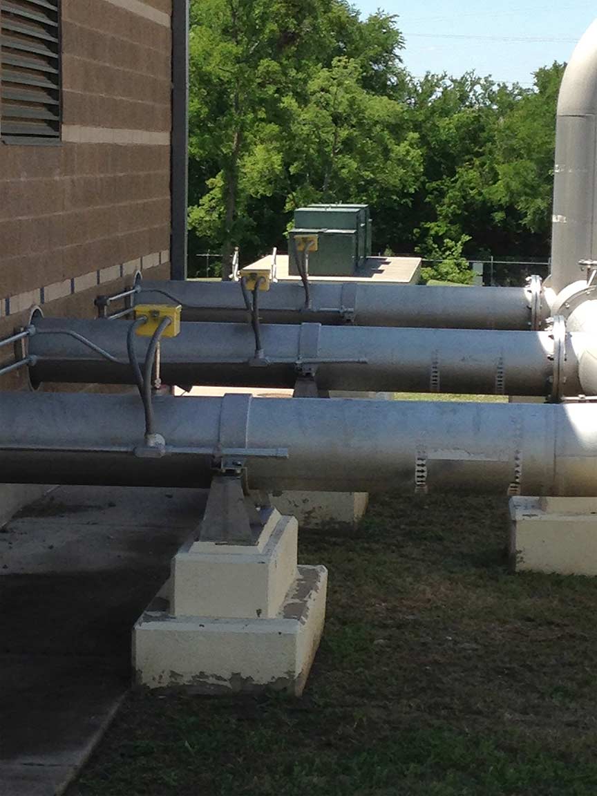 yellow FCI flow meters inserted in large outdoor piping; dallas, texas