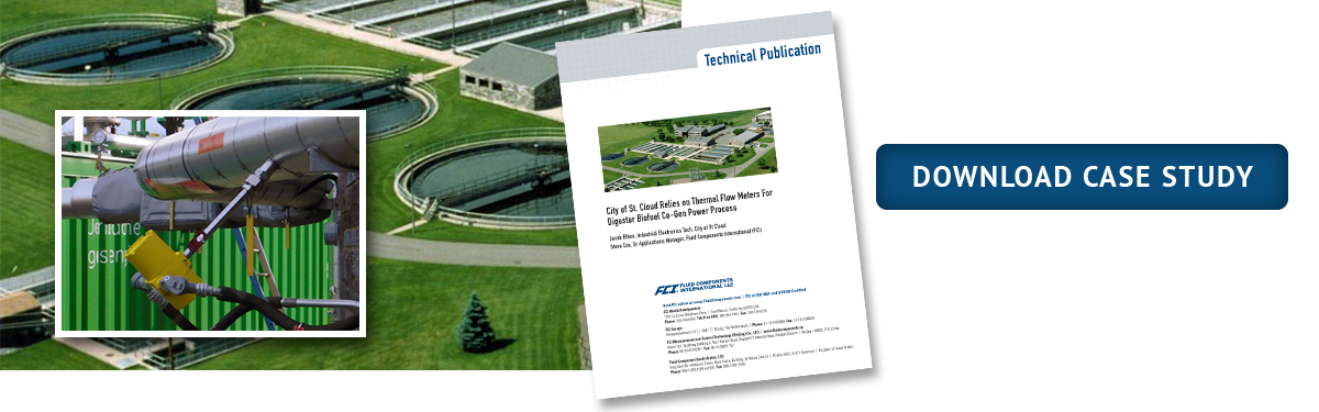 yellow FCI flow meter inserted in DG digester gas pipe; background aerial view of green grass and digester tanks at St Cloud wastewater treatment plant